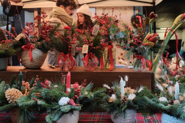 Noel tezgahı şenlikli çiçek aranjmanları, tatil süslemeleri ve el yapımı mevsimlik çelenklerle dolu. Yüksek kalite fotoğraf