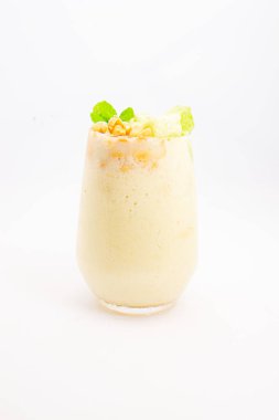 Mısır gevreğiyle kaplı kremalı muzlu smoothie ve beyaz arka planda temiz bardakta servis edilen taze nane şekeri. Yüksek kalite fotoğraf