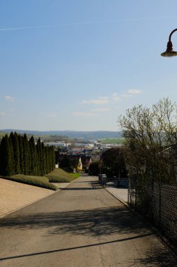 Berrak mavi gökyüzünün altında, uzak ağaçlarla ve huzurlu kırsal alandaki yuvarlanan tepelerle geniş, açık yeşil kırsal alan. Yüksek kalite fotoğraf