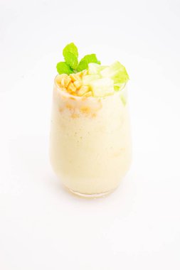 Mısır gevreğiyle kaplı kremalı muzlu smoothie ve beyaz arka planda temiz bardakta servis edilen taze nane şekeri. Yüksek kalite fotoğraf