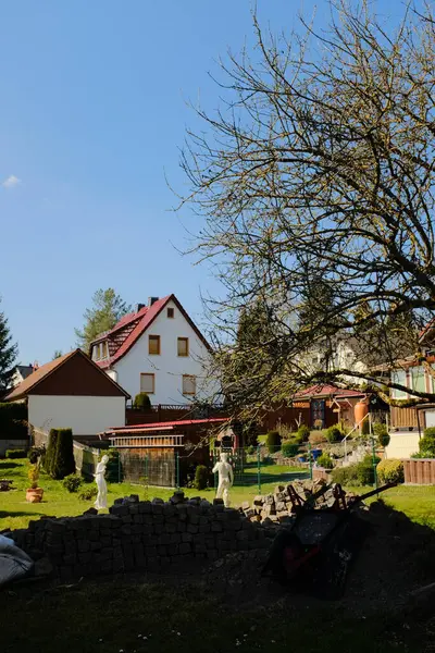 Beyaz paskalya tavşanı heykelleri ve açık gökyüzü altında bahar yeşilliği ile süslenmiş Avrupa köyü bahçesi. Yüksek kalite fotoğraf