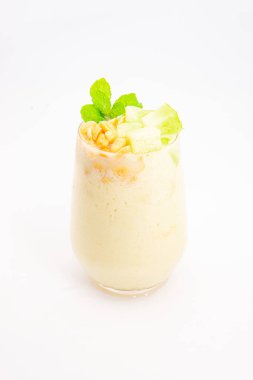 Mısır gevreğiyle kaplı kremalı muzlu smoothie ve beyaz arka planda temiz bardakta servis edilen taze nane şekeri. Yüksek kalite fotoğraf