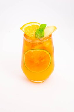 Dilimlenmiş limon ve nane yapraklı ferahlatıcı turuncu narenciye kokteyli beyaz arka planda buzun üzerinde servis edilir. Yüksek kalite fotoğraf