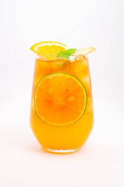 Dilimlenmiş limon ve nane yapraklı ferahlatıcı turuncu narenciye kokteyli beyaz arka planda buzun üzerinde servis edilir. Yüksek kalite fotoğraf