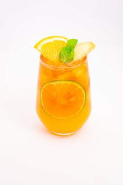 Dilimlenmiş limon ve nane yapraklı ferahlatıcı turuncu narenciye kokteyli beyaz arka planda buzun üzerinde servis edilir. Yüksek kalite fotoğraf