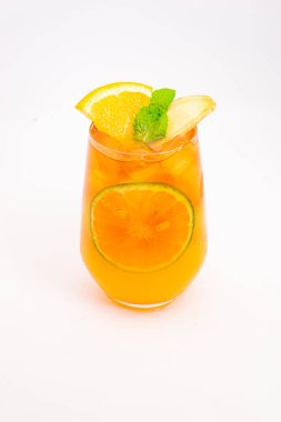 Dilimlenmiş limon ve nane yapraklı ferahlatıcı turuncu narenciye kokteyli beyaz arka planda buzun üzerinde servis edilir. Yüksek kalite fotoğraf
