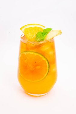 Dilimlenmiş limon ve nane yapraklı ferahlatıcı turuncu narenciye kokteyli beyaz arka planda buzun üzerinde servis edilir. Yüksek kalite fotoğraf