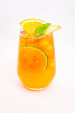 Dilimlenmiş limon ve nane yapraklı ferahlatıcı turuncu narenciye kokteyli beyaz arka planda buzun üzerinde servis edilir. Yüksek kalite fotoğraf