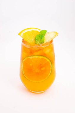 Dilimlenmiş limon ve nane yapraklı ferahlatıcı turuncu narenciye kokteyli beyaz arka planda buzun üzerinde servis edilir. Yüksek kalite fotoğraf