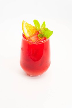 Portakal dilimli canlı kırmızı böğürtlen kokteyli ve beyaz arka planda buzla servis edilen temiz bardakta taze nane yaprakları. Yüksek kalite fotoğraf