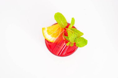 Portakal dilimli canlı kırmızı böğürtlen kokteyli ve beyaz arka planda buzla servis edilen temiz bardakta taze nane yaprakları. Yüksek kalite fotoğraf