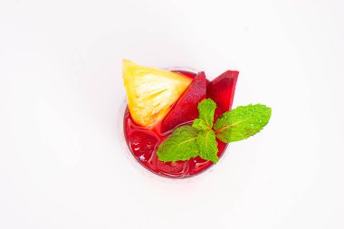 Kırmızı pancar ya da ananas dilimli böğürtlen püresi ve beyaz arka planda şeffaf camla servis edilen naneli garnitür. Yüksek kalite fotoğraf