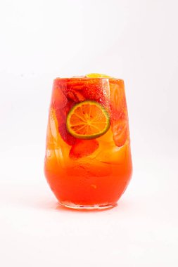 Açık beyaz arka planda şeffaf cam içinde servis edilen dilimlenmiş kumkatlar ve buzla servis edilen parlak kırmızı meyve kokteyli. Yüksek kalite fotoğraf