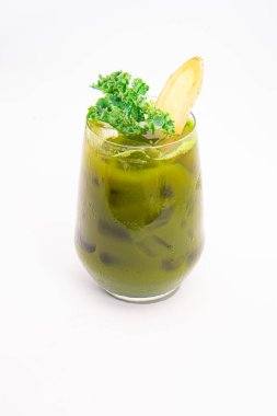 Buzlu yeşil sebze suyu. Beyaz arka planda taze lahana ve zencefil dilimiyle süslenmiş. Yüksek kalite fotoğraf