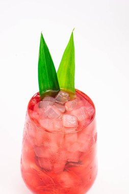 Kırmızıdut kokteyli beyaz zemin üzerinde ezilmiş buz ve yeşil tropikal yapraklarla servis edilir. Yüksek kalite fotoğraf