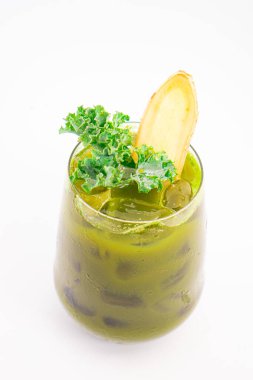 Buzlu yeşil sebze suyu. Beyaz arka planda taze lahana ve zencefil dilimiyle süslenmiş. Yüksek kalite fotoğraf