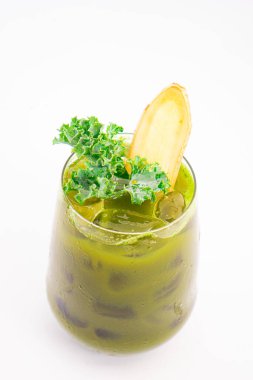 Buzlu yeşil sebze suyu. Beyaz arka planda taze lahana ve zencefil dilimiyle süslenmiş. Yüksek kalite fotoğraf