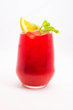 Portakal dilimli canlı kırmızı böğürtlen kokteyli ve beyaz arka planda buzla servis edilen temiz bardakta taze nane yaprakları. Yüksek kalite fotoğraf