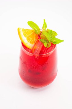 Portakal dilimli canlı kırmızı böğürtlen kokteyli ve beyaz arka planda buzla servis edilen temiz bardakta taze nane yaprakları. Yüksek kalite fotoğraf