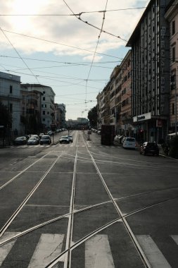 Roma 'nın orta kesişiminde klasik Avrupa mimarisi tarihi binalar tramvay hatları ve bulutlu şehir manzarası altında park edilmiş arabalar. Yüksek kalite fotoğraf