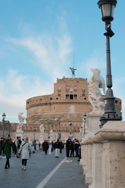 Roma 'daki Castel Sant Angelo ve Ponte Sant Angelo' nun gündüz manzarası Tiber Nehri tarihi mimarisi ve açık mavi gökyüzü boyunca yürüyen turistlerle birlikte. Yüksek kalite fotoğraf
