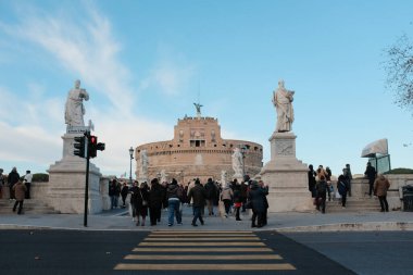 Roma 'daki Castel Sant Angelo ve Ponte Sant Angelo' nun gündüz manzarası Tiber Nehri tarihi mimarisi ve açık mavi gökyüzü boyunca yürüyen turistlerle birlikte. Yüksek kalite fotoğraf
