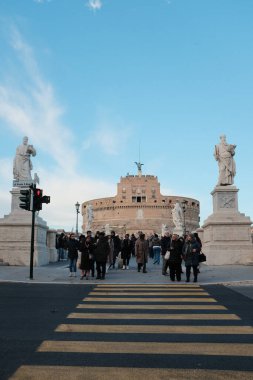 Roma 'daki Castel Sant Angelo ve Ponte Sant Angelo' nun gündüz manzarası Tiber Nehri tarihi mimarisi ve açık mavi gökyüzü boyunca yürüyen turistlerle birlikte. Yüksek kalite fotoğraf