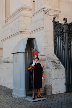 Geleneksel Rönesans üniformalı İsviçreli muhafızlar tarihi taş kemerler ve koruma kabinleriyle Vatikan şehrinin girişinde nöbet tutuyorlar. Yüksek kalite fotoğraf