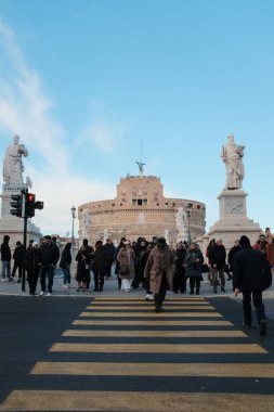 Roma 'daki Castel Sant Angelo ve Ponte Sant Angelo' nun gündüz manzarası Tiber Nehri tarihi mimarisi ve açık mavi gökyüzü boyunca yürüyen turistlerle birlikte. Yüksek kalite fotoğraf