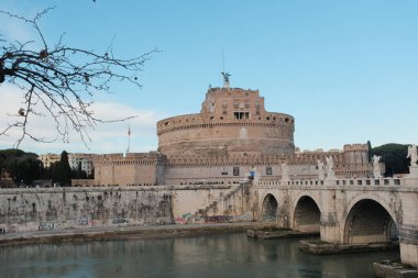 Roma 'daki Castel Sant Angelo ve Ponte Sant Angelo' nun gündüz manzarası Tiber Nehri tarihi mimarisi ve açık mavi gökyüzü boyunca yürüyen turistlerle birlikte. Yüksek kalite fotoğraf