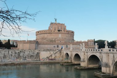 Roma 'daki Castel Sant Angelo ve Ponte Sant Angelo' nun gündüz manzarası Tiber Nehri tarihi mimarisi ve açık mavi gökyüzü boyunca yürüyen turistlerle birlikte. Yüksek kalite fotoğraf