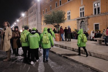 Jubilee, İtalya 'daki Katolik Kutsal Yılı dini etkinliği sırasında gece Roma şehir merkezinde yürüyüş ve organizasyon yapan parlak yeşil ceketli gönüllülerden oluşuyor. Yüksek kalite fotoğraf