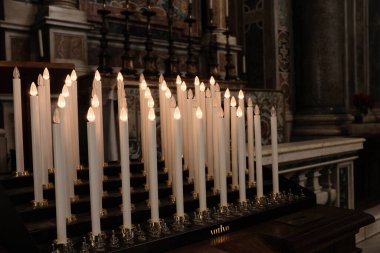 Aziz Peters Bazilikası 'nda yanan beyaz mumlar Vatikan Şehri' ndeki duaların ruhani yansımasını ve sessiz tefekkürü sembolize ediyor. Yüksek kalite fotoğraf