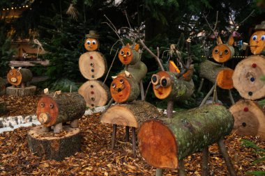 Renkli ahşap figürler rahat bir bahçede tuhaf bir tatil gösterisi yaratarak şenlikli ruhu canlandırıyor.