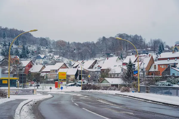 Büyülü kış mevsiminde büyüleyici küçük bir köyde zarif bir şekilde dönen karlı bir yol.