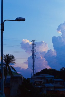 Yükselen kümülüs bulutları gün batımında açık mavi gökyüzüne karşı altın güneş ışığıyla parlarken dramatik doğal bulutlar ve atmosferik ışıkla birlikte. Yüksek kalite fotoğraf