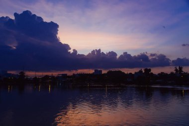 Yükselen kümülüs bulutları gün batımında açık mavi gökyüzüne karşı altın güneş ışığıyla parlarken dramatik doğal bulutlar ve atmosferik ışıkla birlikte. Yüksek kalite fotoğraf