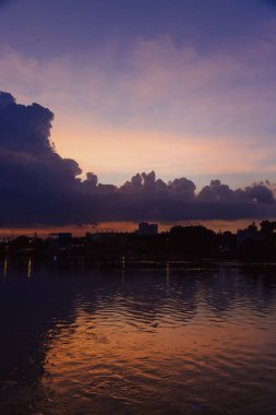 Yükselen kümülüs bulutları gün batımında açık mavi gökyüzüne karşı altın güneş ışığıyla parlarken dramatik doğal bulutlar ve atmosferik ışıkla birlikte. Yüksek kalite fotoğraf