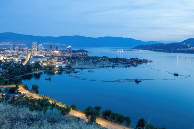 Panoramic view of Kelowna at sunset from Knox Mountain Park, featuring the William Bennett Bridge, Okanagan Lake, and distant mountains clipart