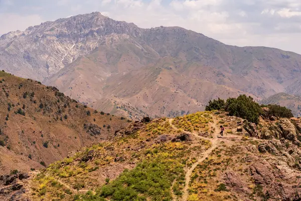 Özbekistan 'ın Taşkent kenti yakınlarındaki Amirsoy kayak kaldırma istasyonu yakınlarında güneşli bir günde yürüyüş yapan bir çocuk görülüyor. Kurak, engebeli manzara bölgenin doğal güzelliğini ve maceracı ruhunu vurguluyor..