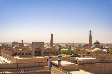 Khiva 'nın eski kasabasının manzarası, sıcak öğleden sonra güneşinin altında güneşlenen canlı mimarisini ve zengin tarihini gözler önüne seriyor..