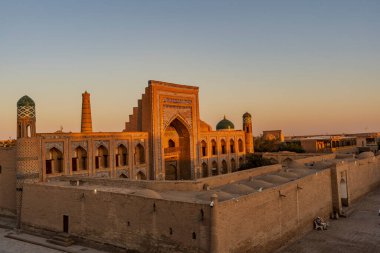 Muhammed Rahim Khan Madrasah 'ın göz kamaştırıcı yüzü yaz güneşinin altında ışıl ışıl parlıyor. Khiva' nın eski kasabasında kartonpiyer ve tarihi bir cazibe sergiliyor.
