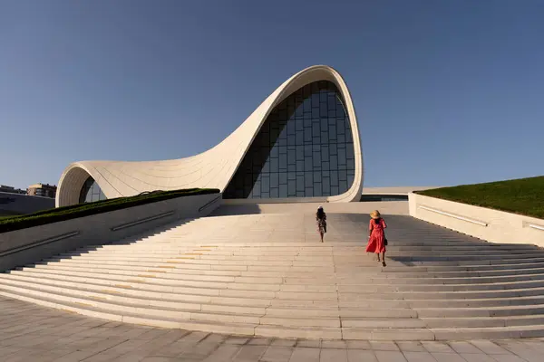 Bir kadın ve kızı Azerbaycan 'ın Bakü kentindeki Heydar Aliyev Merkezi' ne çıkan merdivenleri çıkıyorlar. Parlak güneşli bir günde merkezin gelecekteki mimarisi vurgulanır..