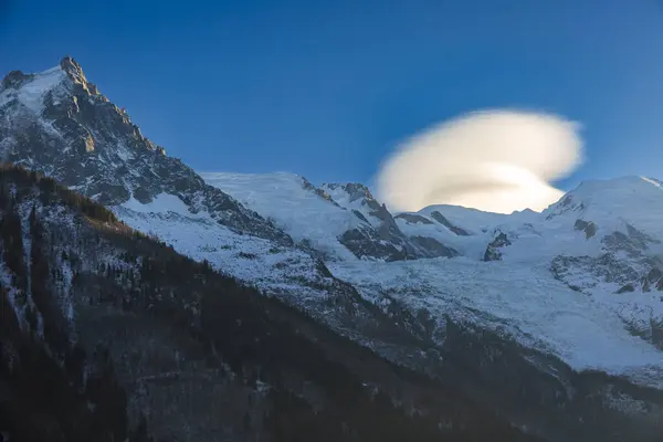 Chamonix 'deki karlı dağların üzerinde açık bir gökyüzünde bulut desenleri. Güneşli bir kış gününde çekilmiş.