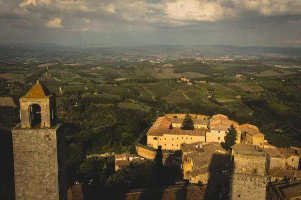 San Gimignano 'dan Torre Grossa' nın manzara manzarası ötesindeki engin manzarayı ve aşağıdaki büyüleyici eski kasabayı gösteriyor..