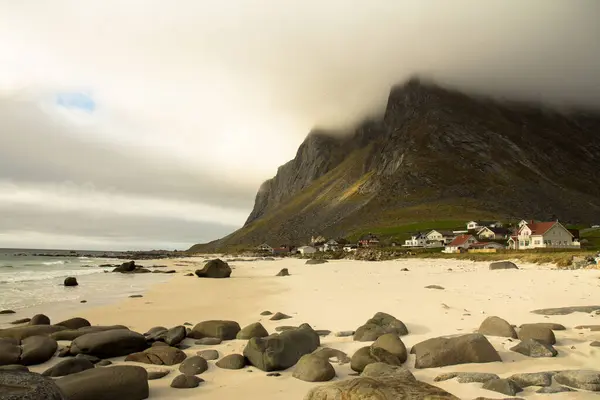 Norveç, Lofoten 'de bir sahil. Dağları alçak bulutlar kaplıyor. Sakin ve manzaralı bir sahil manzarası..
