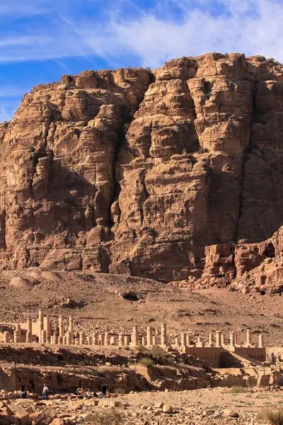 Petra, Ürdün 'deki Büyük Tapınak' ın kalıntıları, güneşli bir günde arka planda yükselen heybetli kayalık kayalıklar..