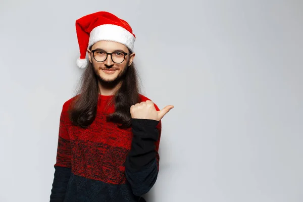 Uzun Saçlı Gözlüklü Işaret Parmağıyla Işaret Eden Kırmızı Noel Süveteri — Stok fotoğraf