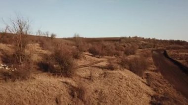 Aerial view of dirty rural road in dry field.