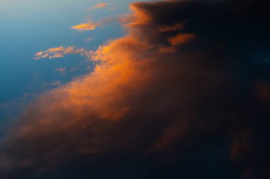 Koyu bulutlu, renkli günbatımının doğal manzarası.